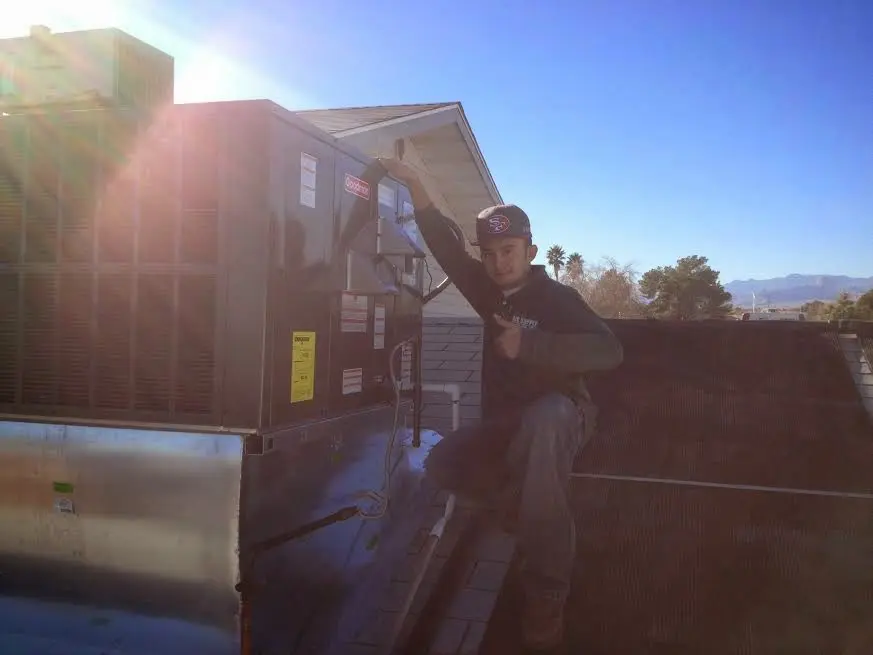 HVAC technician performing HVAC Inspection on a rooftop unit in Homewood